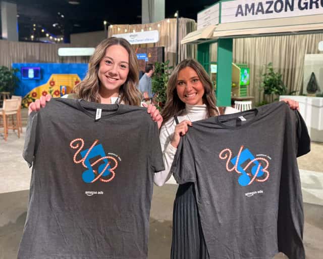 Two guests holding tees printed live at their event